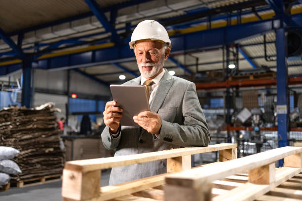 istock Senior manager with hardhat checking production results on digital tablet. 2192542314
