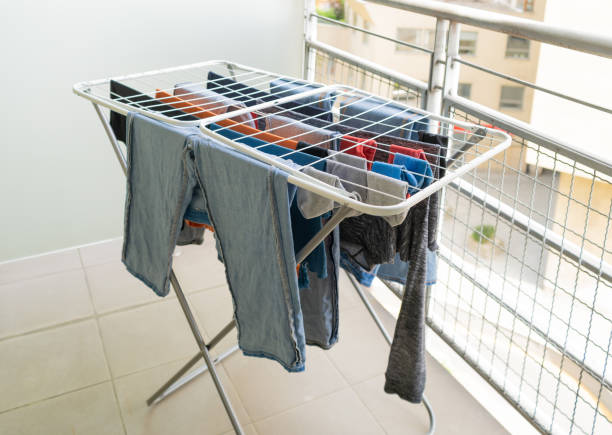 istock Laundry drying on a balcony clothes rack, with various garments including jeans and shirts 2192543424