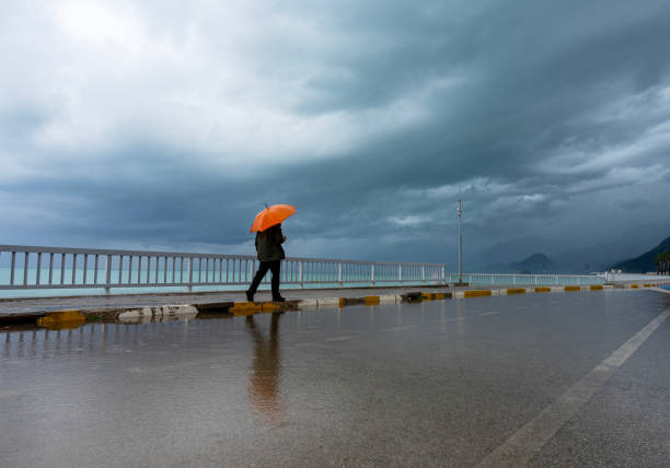 man walking in the rain - yağmur firtina stok fotoğraflar ve resimler