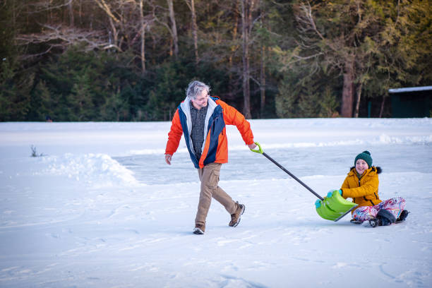 istock 53-year-old father pulls autistic son on snow slider during outdoor activity 2192547449