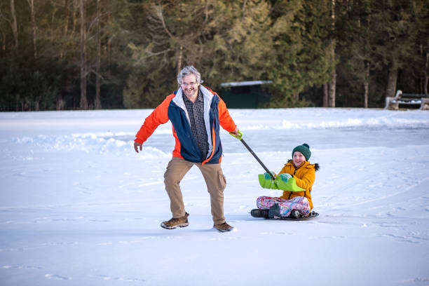 istock Mature man pulls his autistic teen on snow slider during outdoor activity 2192547453