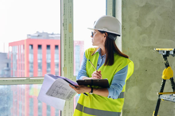 istock Technical profession woman in protective vest helmet working on construction 2192548690