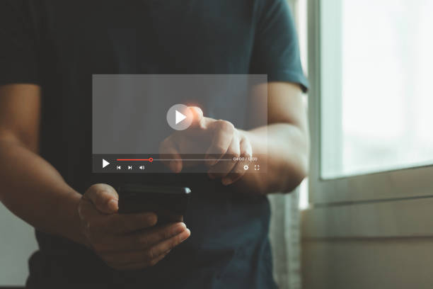 istock Video streaming online, watching video on internet hologram concept. Man hand holding mobile smartphone playing video stream online network media service and Digital marketing technology for business. 2192549296