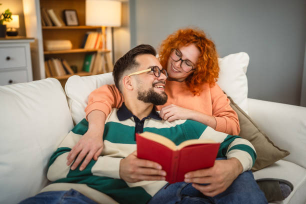 istock cheerful couple enjoy together on sofa and read book together 2192549969