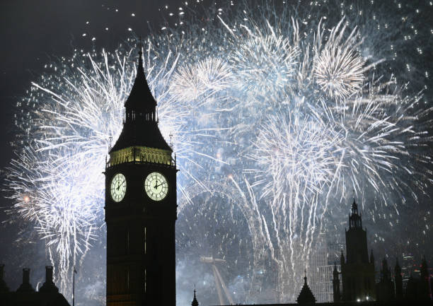 Big Ben and the Houses of Parliament clock tower surrounded by fire works at midnight on New Year's Eve. London, UK