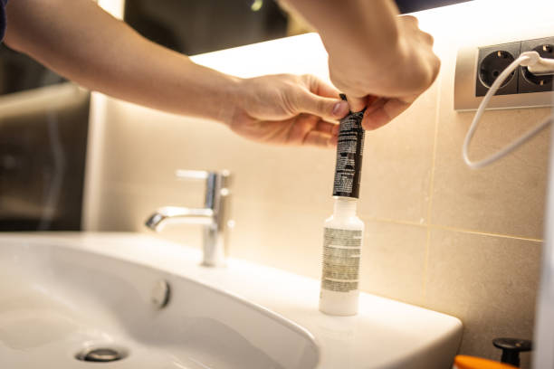 istock Unrecognizable Person Squeezing hair color into a Bottle in a Modern Bathroom Setting 2192555983