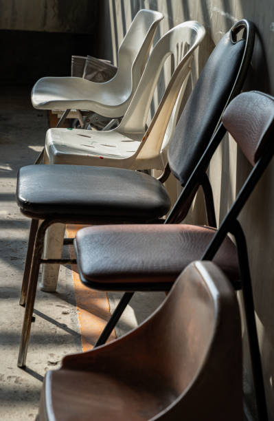 istock Perspective side view of Different of Chairs with Morning sunlight shines through with concrete wall in the background. 2192557416