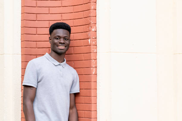 istock Young black man smiling near a brick wall 2192557835