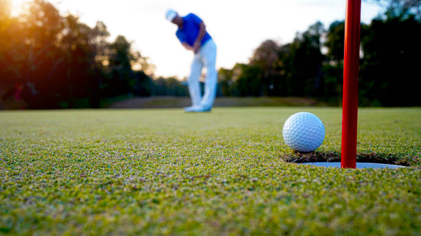 istock Golfers are putting golf in the evening golf course golf backglound. Golfer hitting golf ball. 2192560629