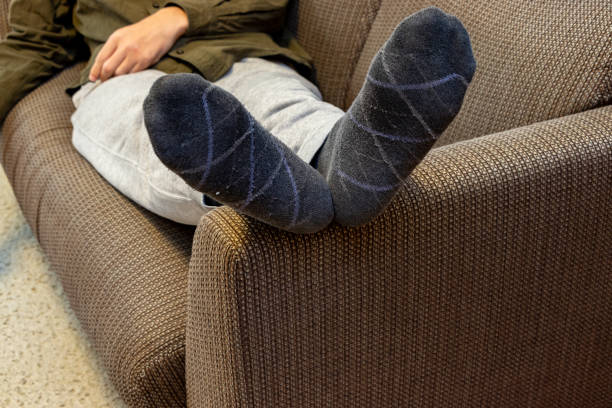 istock Man lying on sofa with feet up on armrest 2192560786