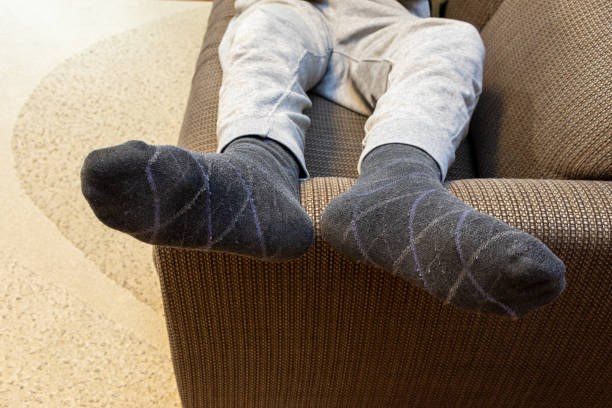 istock Man lying on sofa with feet up on armrest 2192560794