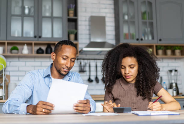 istock Young couple looking glumly at their monthly bills 2192569107