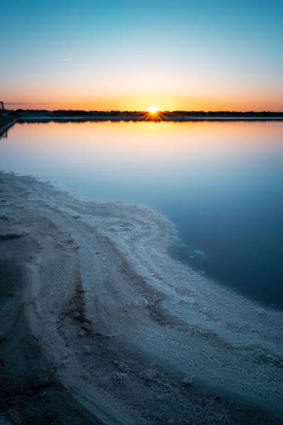 Sunset at Salinas de Aigues Mortes, salt flats where salt is harvested in the Camargue, Aigues- Mortes, France, Europe