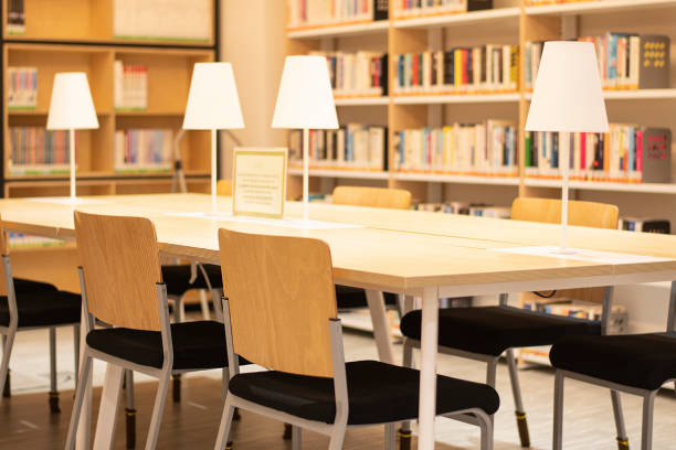 Cute young woman at a table with a book in a library