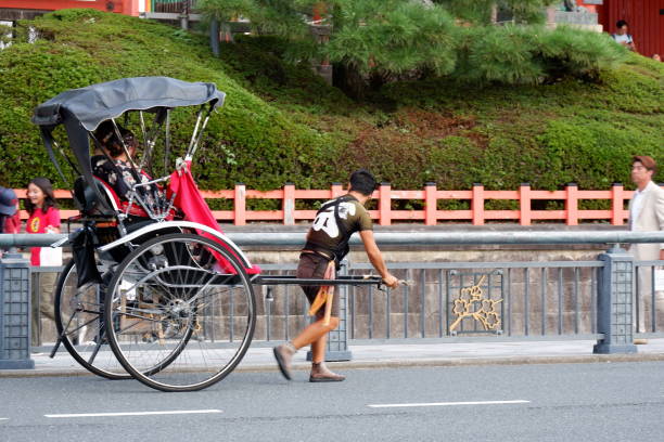 Japanese Man pulling rickshaw with tourists in Kyoto City