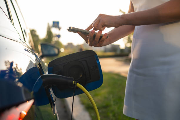 istock Close up woman hands using smart phone for payment for charging electric car. 2192585317