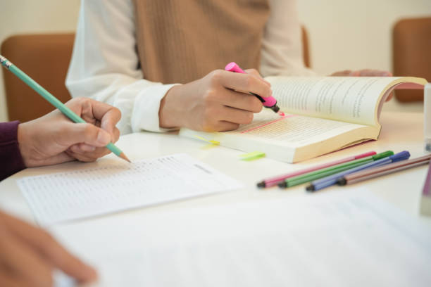 istock Learning with friends Young students campusHigh School Tutor for examining helps school homework together withÂ friend catching up and learning 2192587778