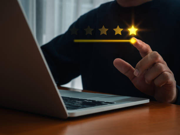 istock Five stars rating review, positive experience, press by customer hand who using laptop computer for online service evaluation on app. Customer satisfaction, ratings, client feedback survey concepts. 2192587987