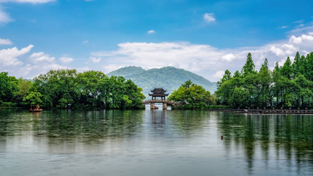 istock Tranquil Lakeside Scene with Pavilion Surrounded by Lush Greenery 2192588055