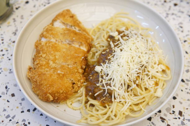 istock A plate of spaghetti topped with grilled chicken, garnished with herbs, presented appetizingly 2192589344