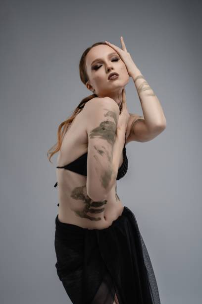 istock Model poses gracefully in a studio with stylish tattoos and elegant attire 2192590454