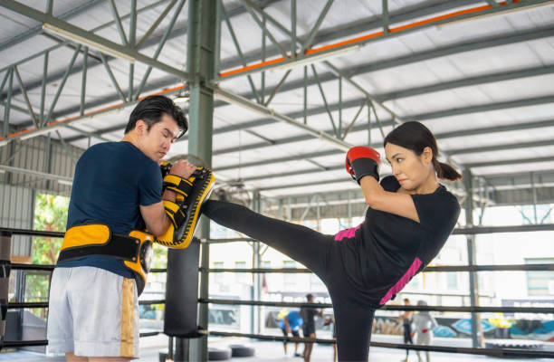 istock female kick-boxer practising with coach in boxing ring 2192592283