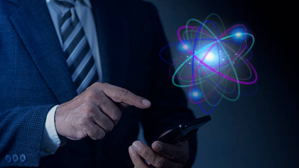 istock Businessman hand using smartphone with abstract glowing atom hologram on dark background. Nuclear fusion concept, Endless energy, Cheap electricity, Future technologies. Science and future concept 2192594621