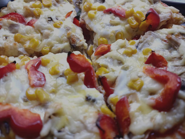Close up of pizza with corn, pepper, tomato and mozzarella