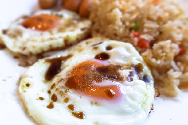 Closeup side view of fried egg with soy and pepper.