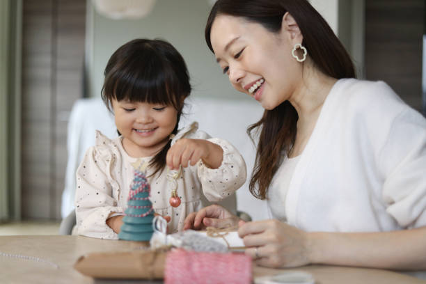 istock Parents and children decorating a small Christmas tree 2192598716