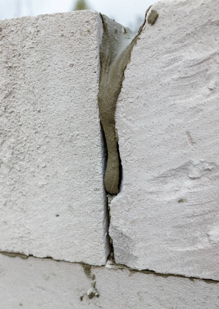 istock A white brick wall with a crack in it 2192600078