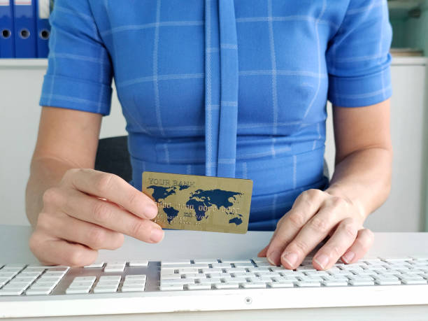 istock Individual using a credit card while working at a desk with a computer in a modern office environment 2192600802