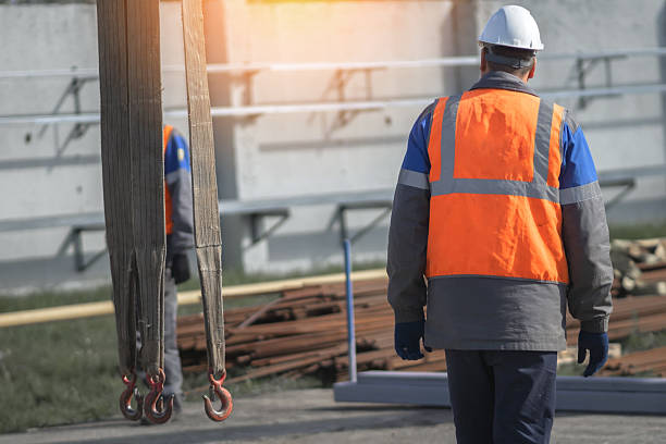 Male construction worker inspecting building site with safety gear