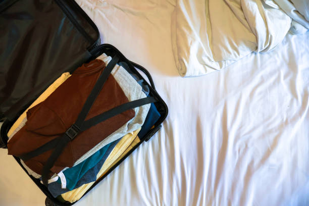 istock Open black suitcase with clothes packed for travelling on the bed 2192602303