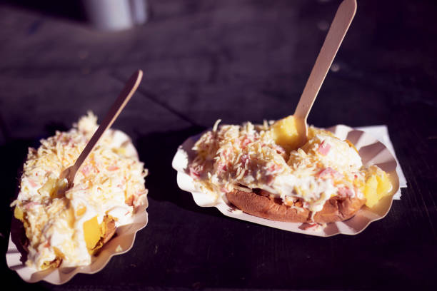 Hot potatoes stuffed with cheese, sour cream and ham at an outdoor (Christmas) market.