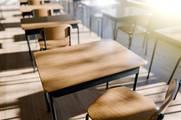 minimalist classroom setting with wooden desks emphasizing a peaceful learning environment filled with natural light. 3d render. - utbildning bildbanksfoton och bilder