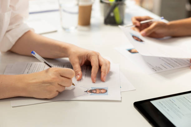 istock HR manager writing signature on documents after evaluating applicant 2192613617