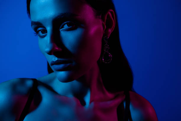 istock Creative portrait with dramatic lighting showcasing a woman's thoughtful expression in blue and pink tones 2192613866