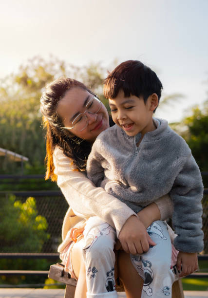 žena se svým synem se ráno objímají venku v letním dni. - dobrovolná skromnost životní styl fotky - stock snímky, obrázky a fotky