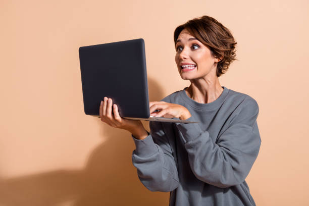 istock Photo of ecstatic eccentric funny woman dressed grey pullover play excited video game on laptop isolated on pastel color background 2192616438