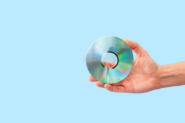 istock Close up of Hand holding compact disc on light blue background 2192618784