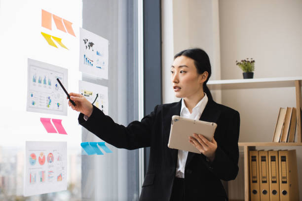istock Asian businesswoman presenting data charts in modern office setting 2192621641