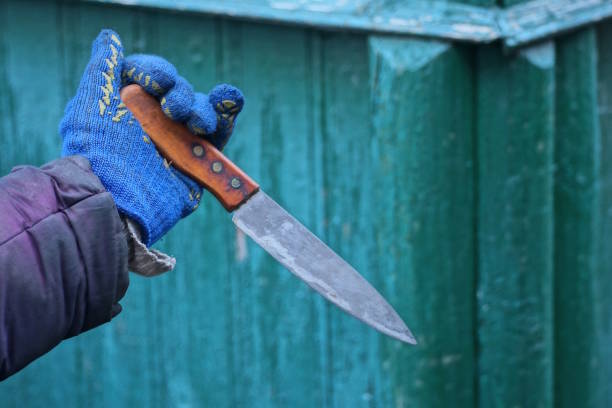 istock one hand in a blue glove swings a large knife 2192625356