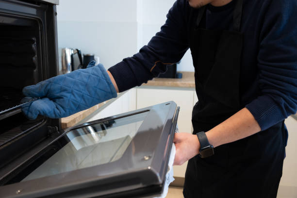 istock Man removing hot oven rack with glove 2192631143