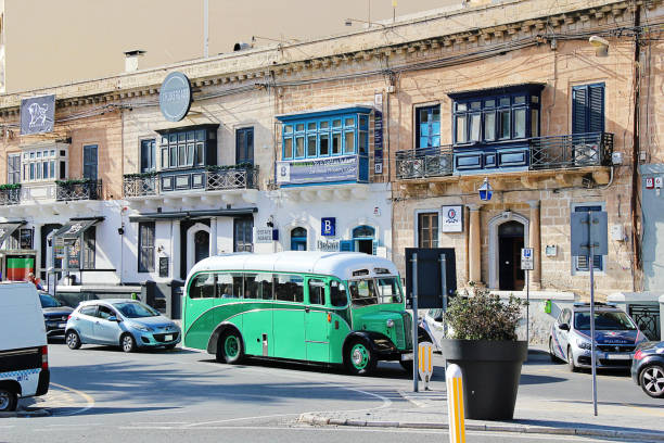Sliema,Maltese Islands  - October 26, 2013: Alone driver with no passengers driving his 1960's AFC Reliance Bedford bus through traffic on the promenade road of Sliema, a residential and touristy area. This bus is a mobile souvenir shop just finished trading for the day.