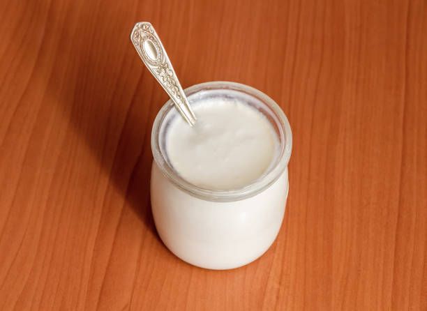 Homemade sour milk product of beneficial bacteria in a jar on the kitchen table close-up.