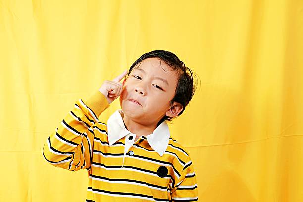 Photo of carefree fooling kid dressed white shirt rising arms palms bloated cheeks empty space isolated yellow color background.