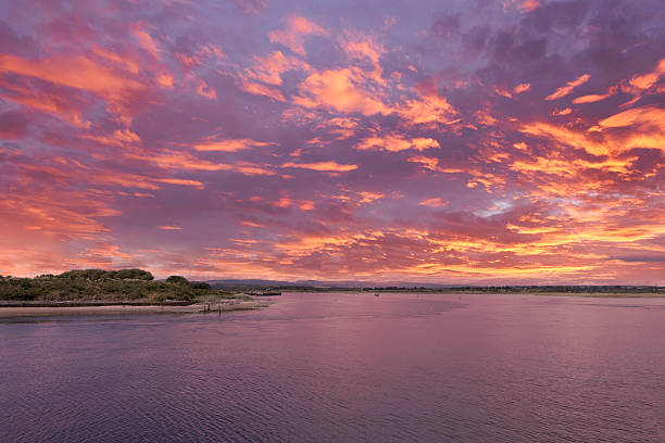 Looking out North accross the old maratime harbour at Irvine on the North Ayrshire Coast of Scotland. The old harbour at sunset looking over to Ardeer in the far distance at sunset with a blazing red sky. beach fire scotland stock pictures, royalty-free photos & images