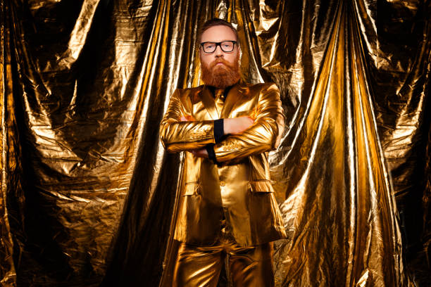 A mature gentleman exudes sophistication and style in a golden suit, posing confidently against a shimmering background, perfect for holiday and party themes.