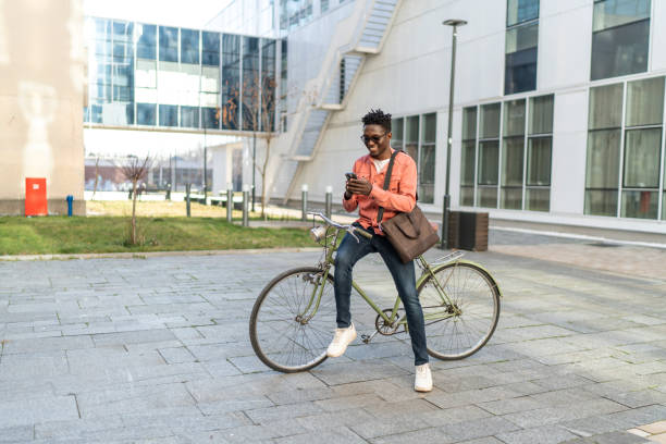 istock Young man with bike using cell phone 2192639349
